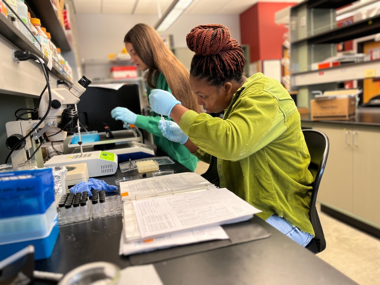 Two NKU undergraduate STEM majors conducting biology research in a lab