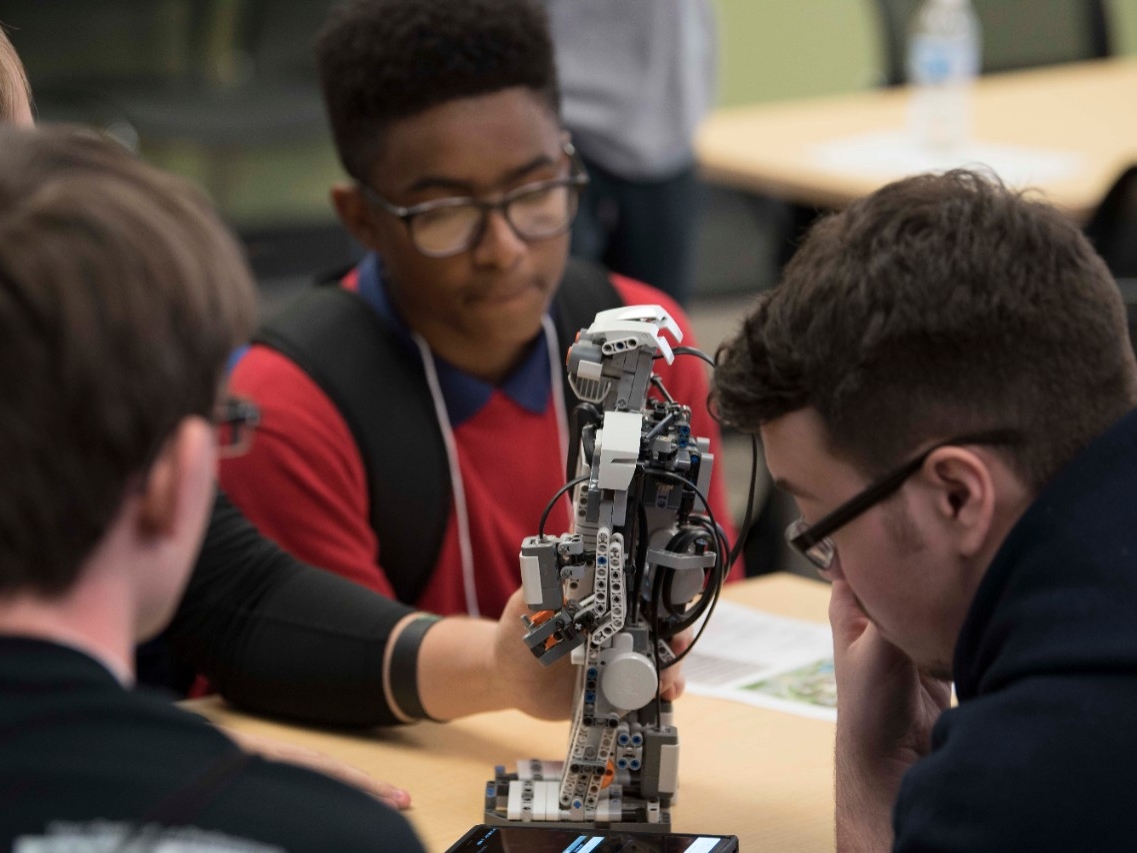 High school students enjoying an engineering activity at High School STEM+H Day event