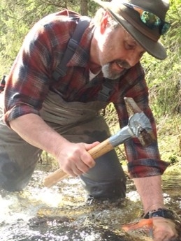 Photo of Dr. Durtsche doing research in a creek bed.