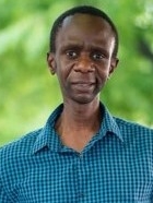 Photo of Dr. Oluoch, outside in a wooded area