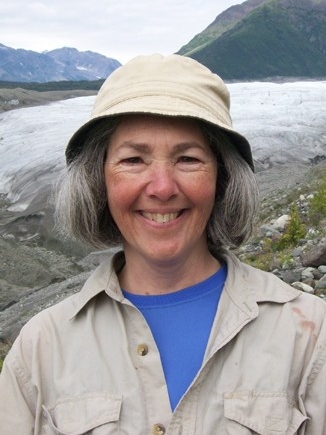 Dr. Curran smiles with water and mountains in the background.