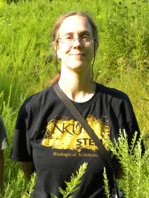 A photo of Dr. Whitson standing outside in tall grass with a student.