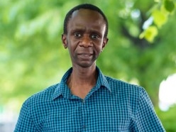 Photo of Dr. Oluoch, outside in a wooded area