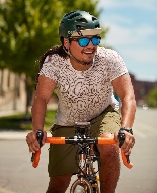 Tanner Yess smiles while riding a bike on a sunny day.