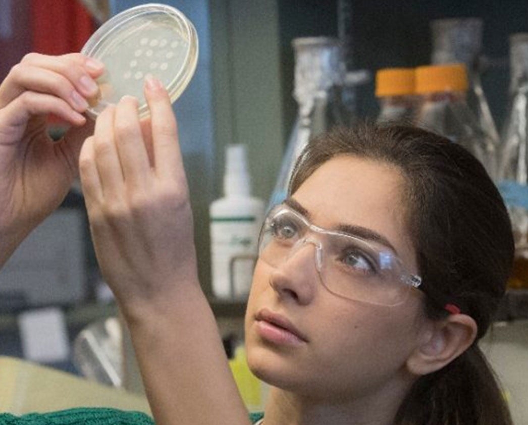 Student inspecting a sample inside chemistry lab.