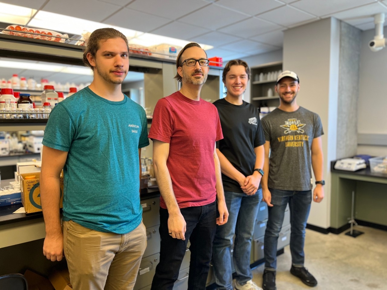 NKU Chemistry research students and faculty pause their work to smile for a picture in the lab.