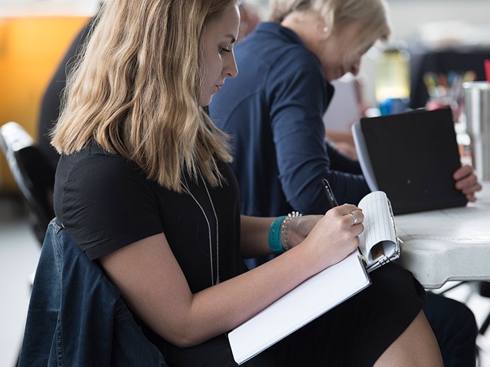 Student taking notes during a meeting