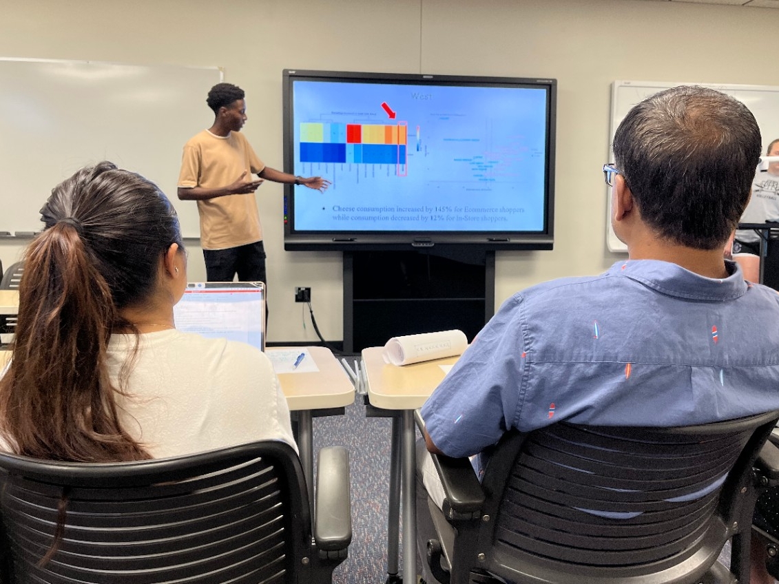 A student presents research to peers and faculty.