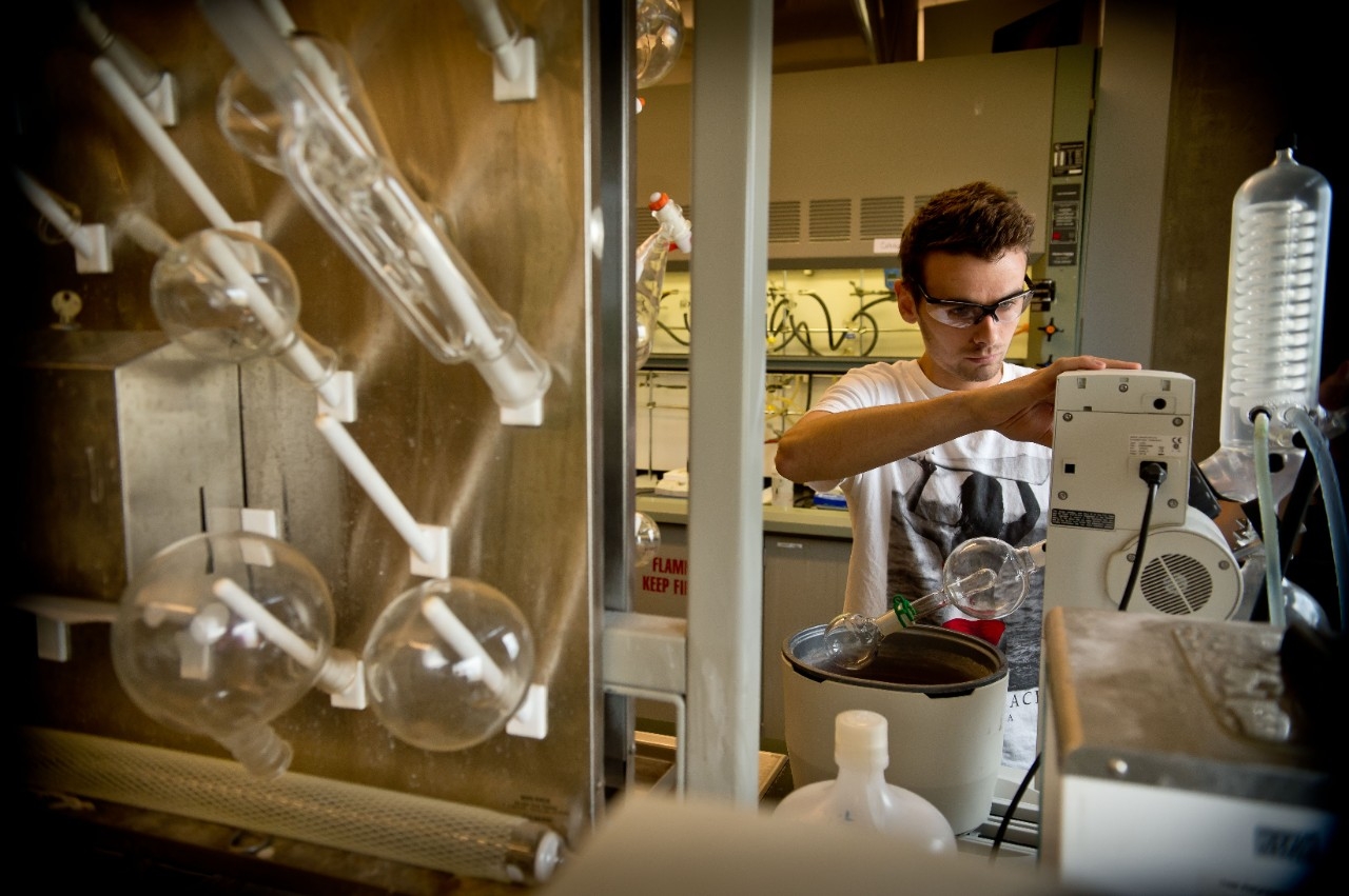 Chemistry student working on equipment inside lab.