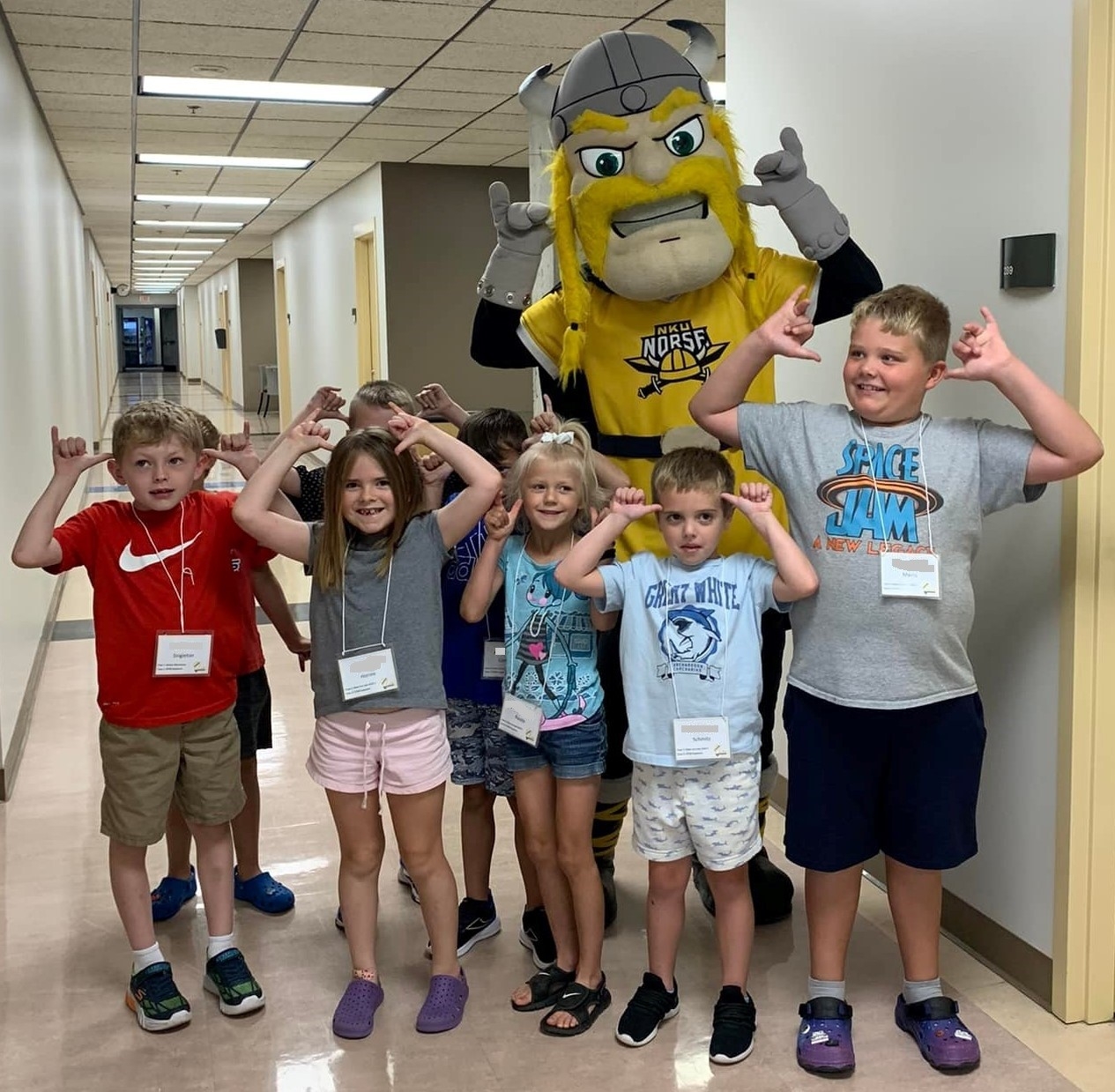 five children pose with the Victor E Viking mascot