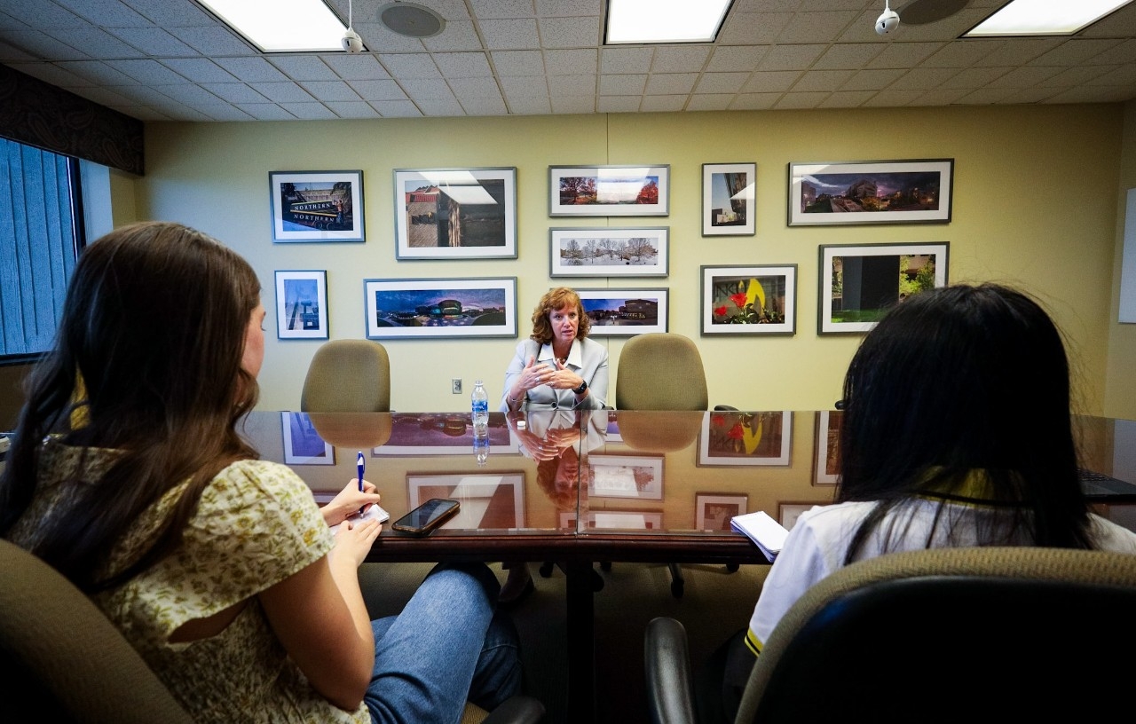 Students gathered at a table with President Cady Short-Thompson