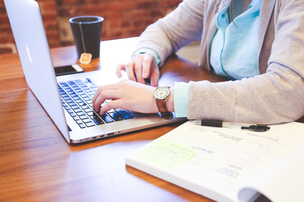 Person working at a desk on their laptop.