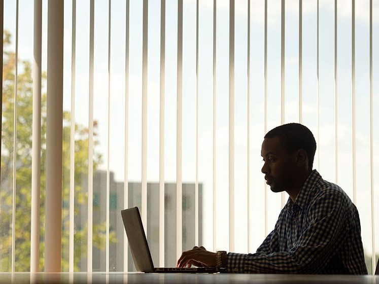  Silhouette of law student at laptop working in an office