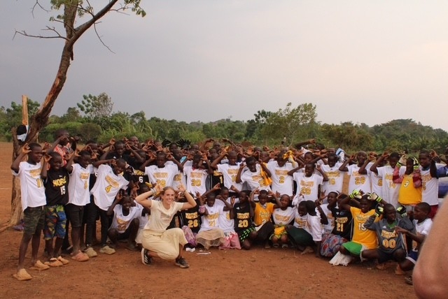 Natalie Newman standing with children in Uganda