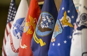 Close-up photo of six flags presenting each branch of the United States military alongside the American flag. 